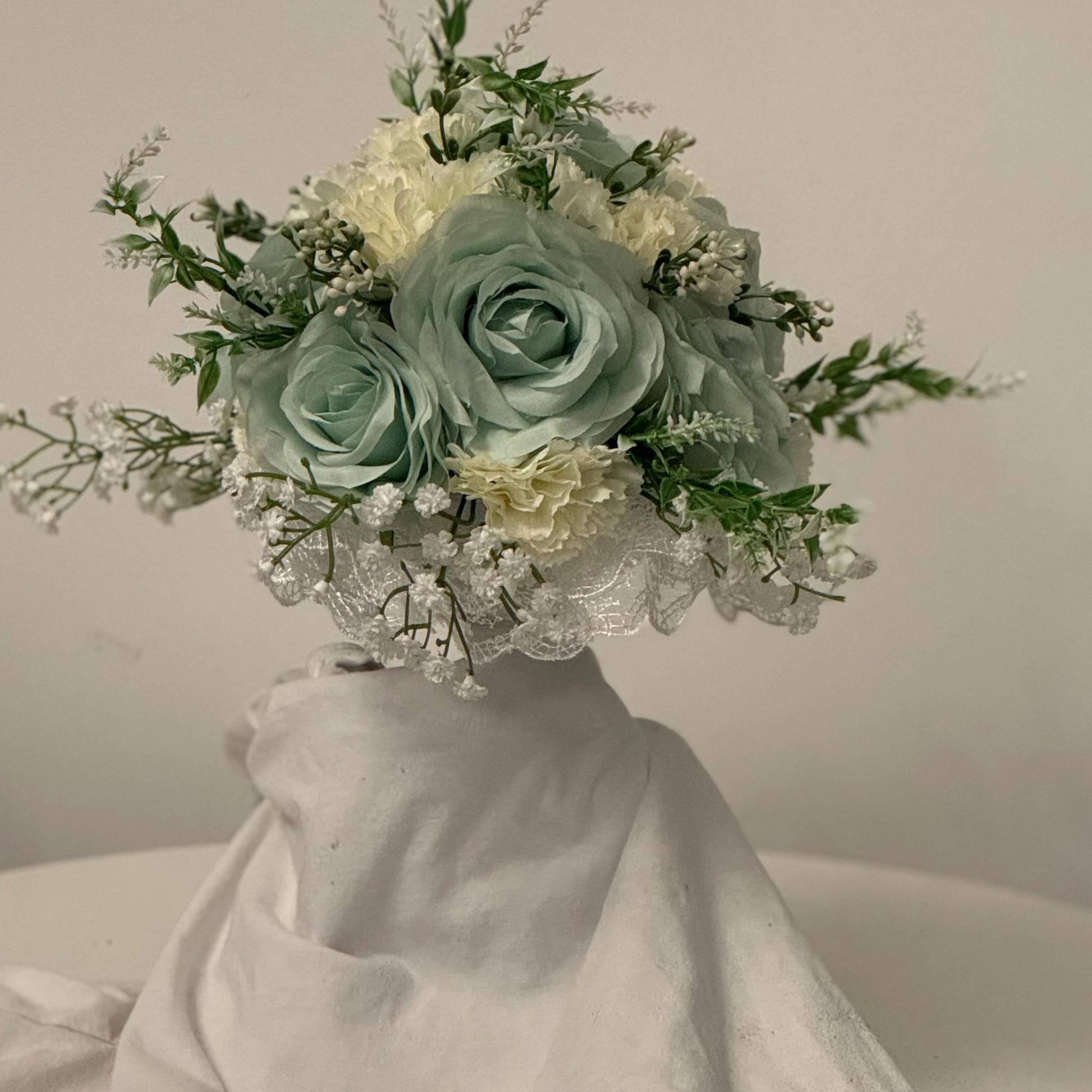 Artificial wedding bridal bouquet with sage green roses and ivory carnations with foliage