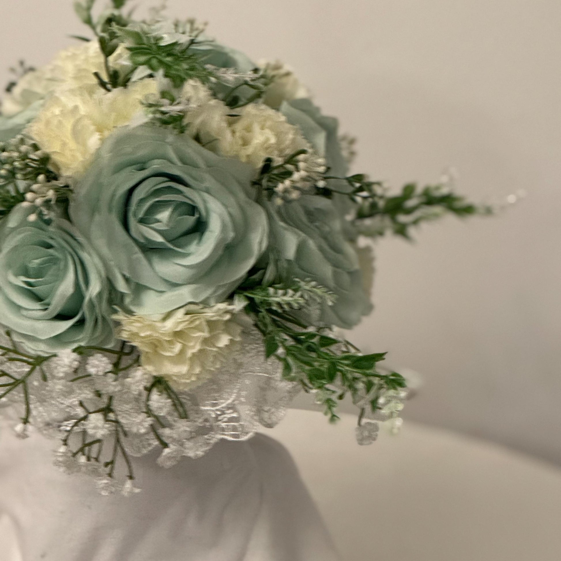 Artificial wedding bridal bouquet with sage green roses and ivory carnations with foliage