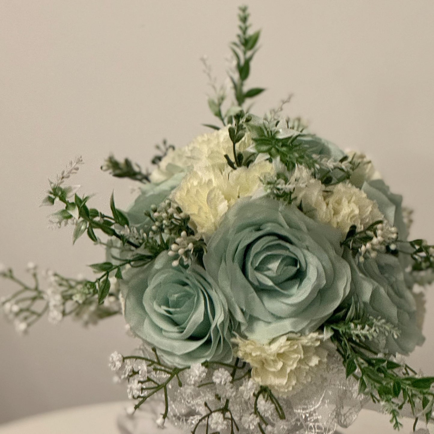 Artificial wedding bridal bouquet with sage green roses and ivory carnations with foliage