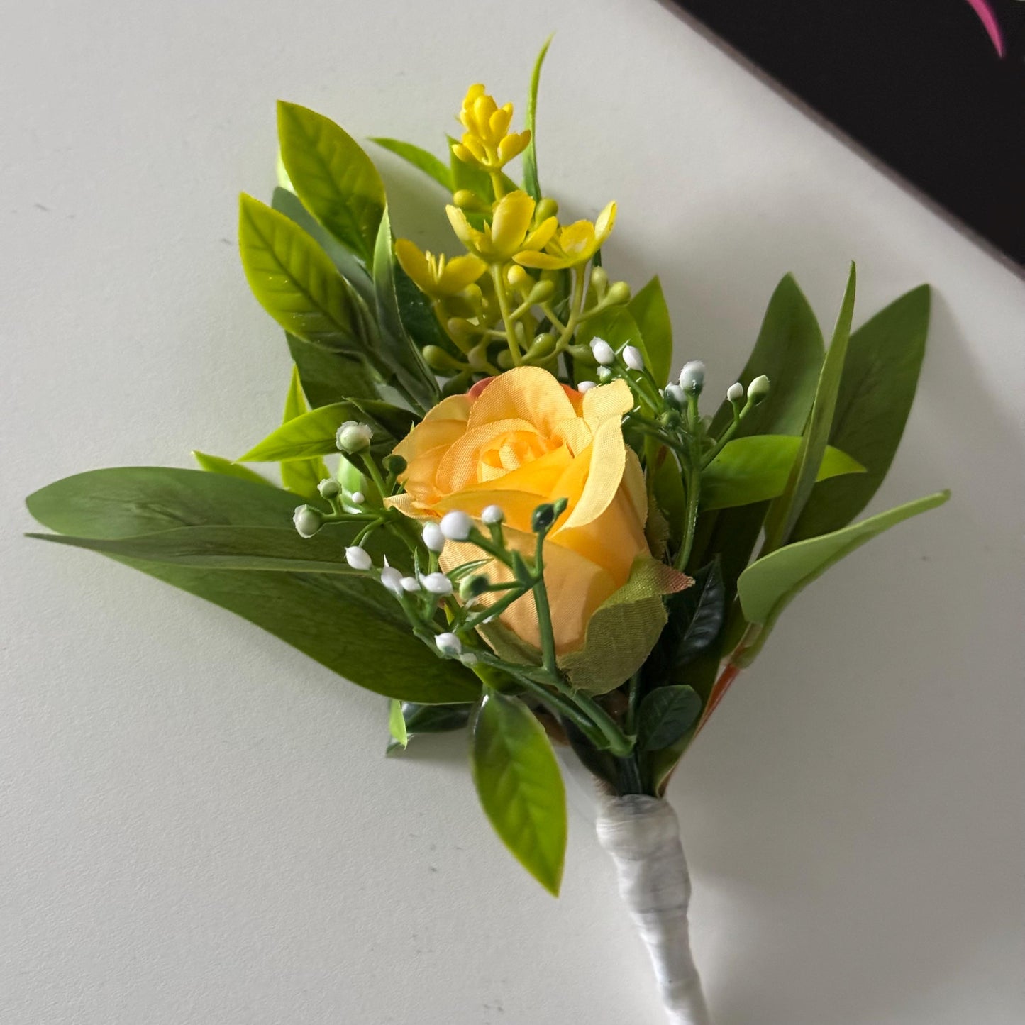 Artificial wedding single yellow rosebud with foliage buttonholes. Ideal for spring/summer weddings