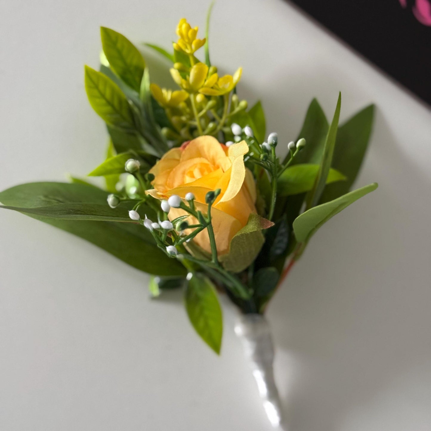 Artificial wedding single yellow rosebud with foliage buttonholes. Ideal for spring/summer weddings