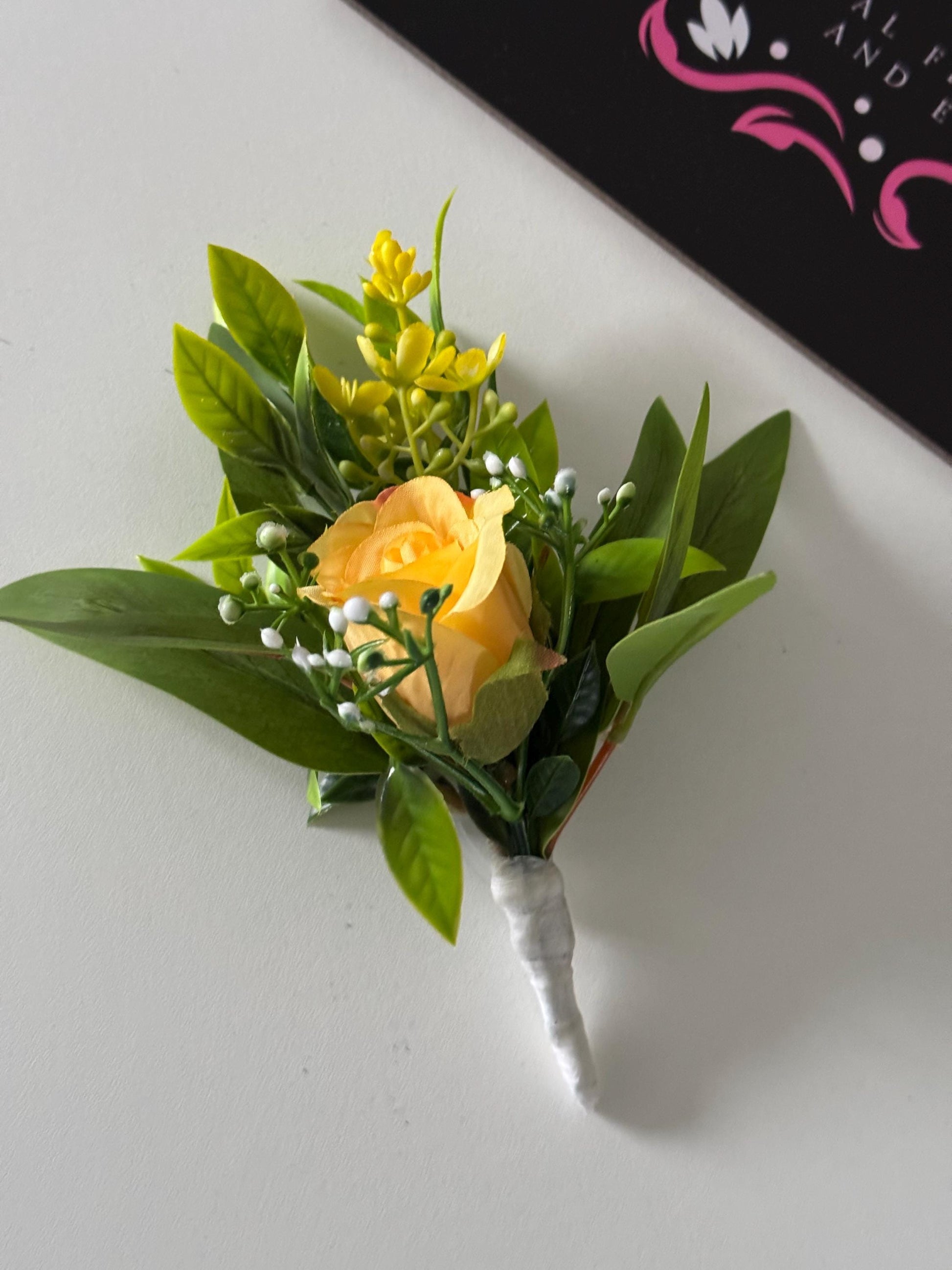 Artificial wedding single yellow rosebud with foliage buttonholes. Ideal for spring/summer weddings