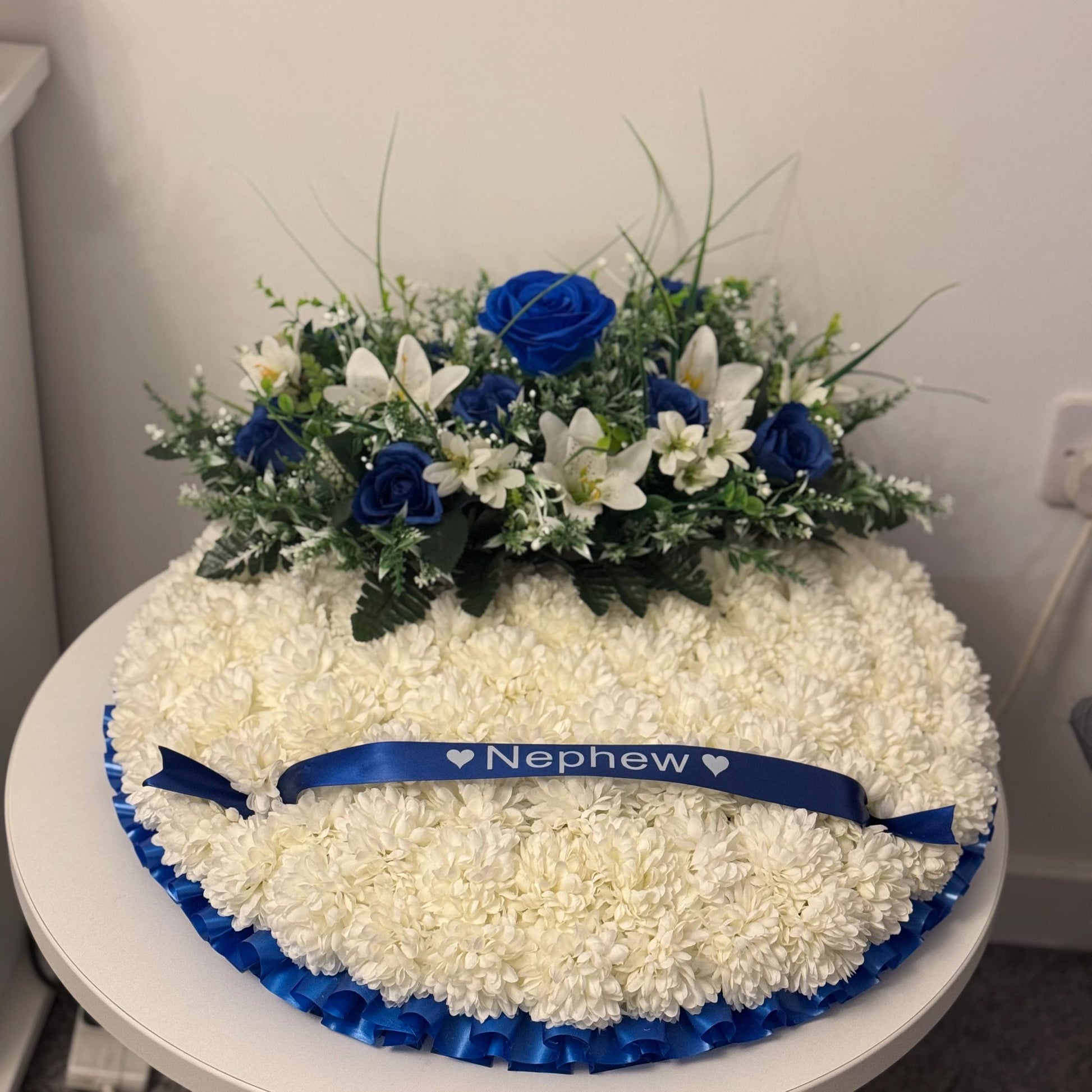 Posey 18 “ Shaped Silk Artificial Funeral Flowers Wreath/Memorial/Grave Tributes with blue roses, white lily’s and green foliage