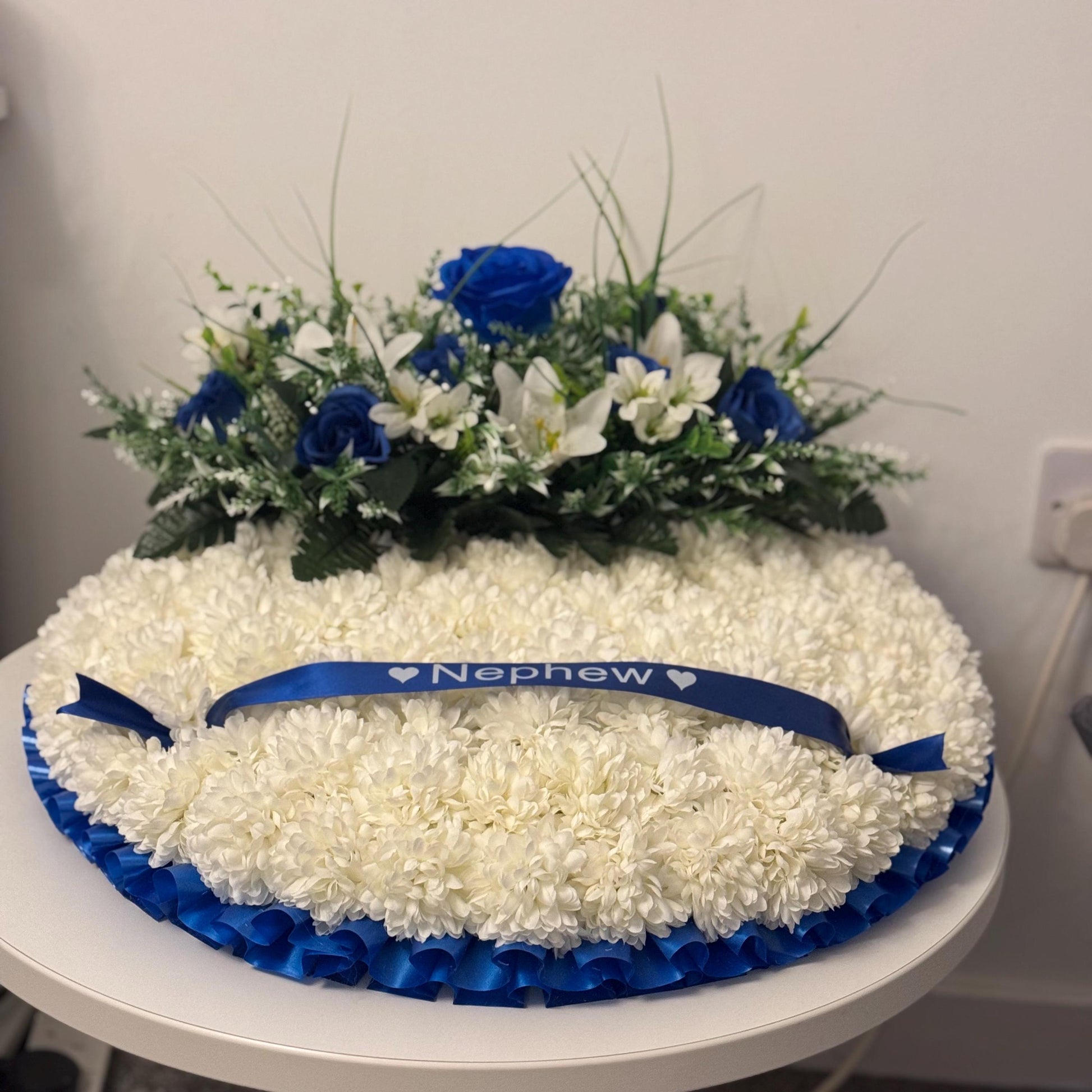 Posey 18 “ Shaped Silk Artificial Funeral Flowers Wreath/Memorial/Grave Tributes with blue roses, white lily’s and green foliage