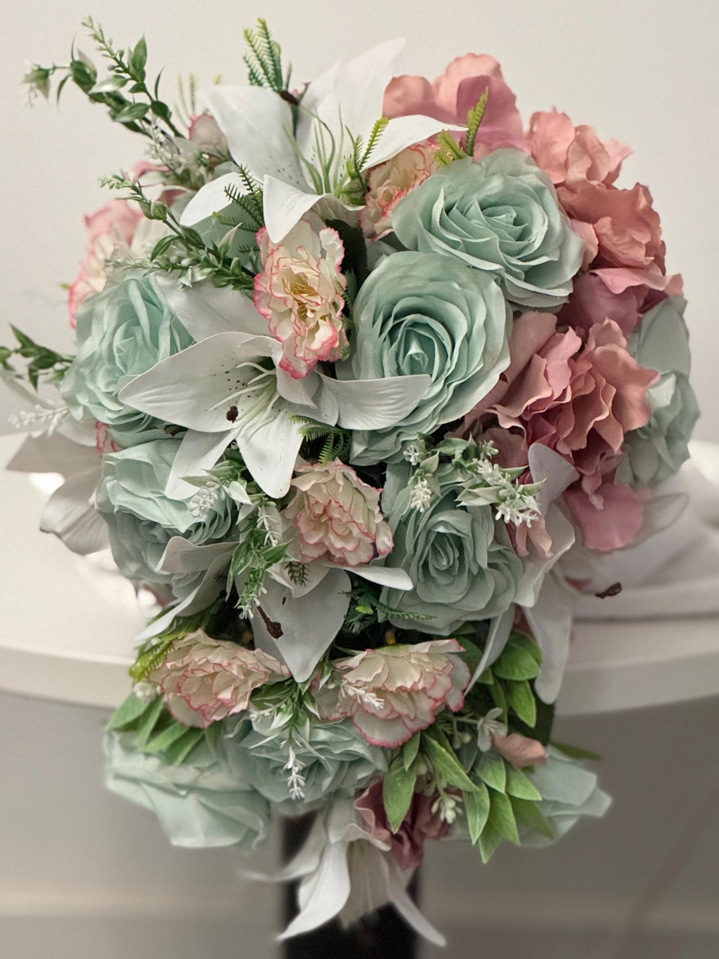 Artificial wedding bridal teardrop bouquet with blush pink hydrangeas , sage green roses and white Lilies with foliage