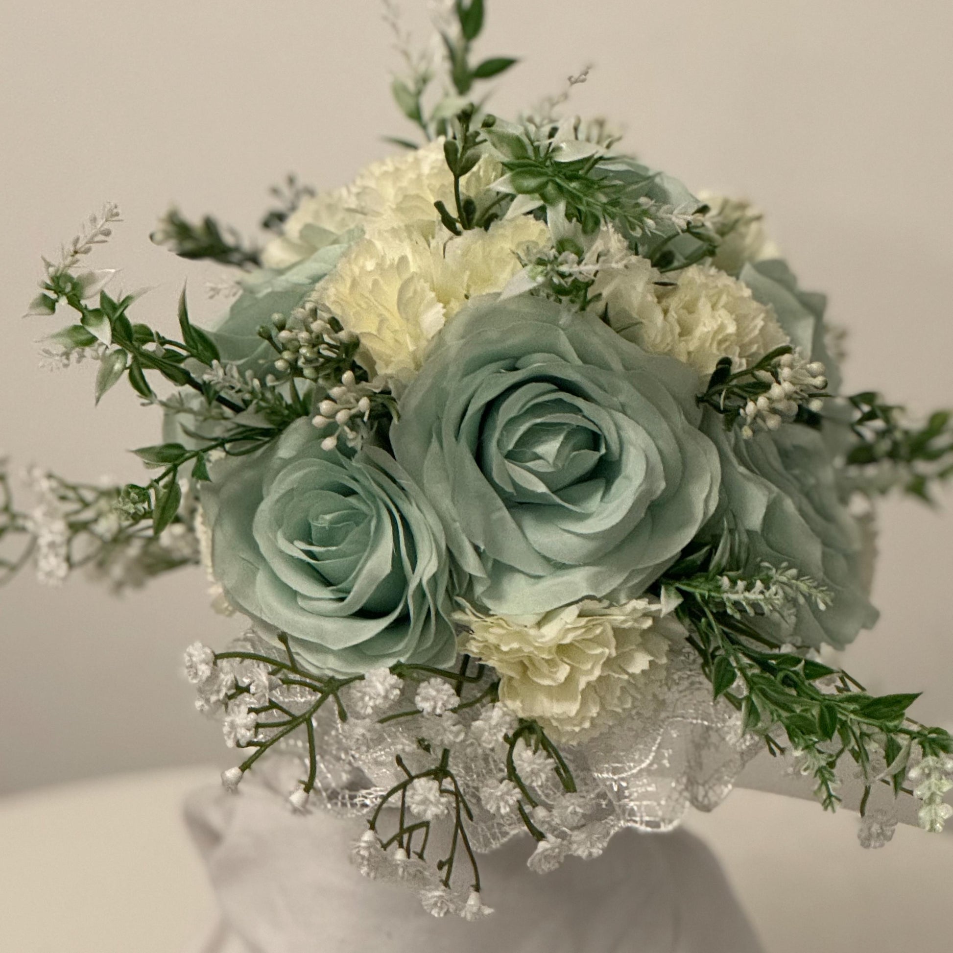 Artificial wedding bridal bouquet with sage green roses and ivory carnations with foliage