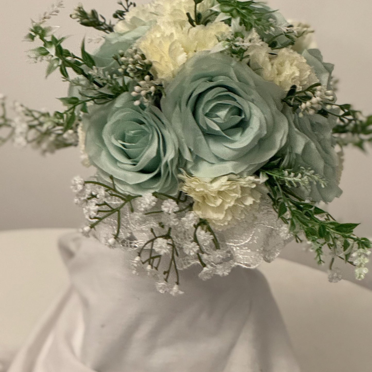 Artificial wedding bridal bouquet with sage green roses and ivory carnations with foliage