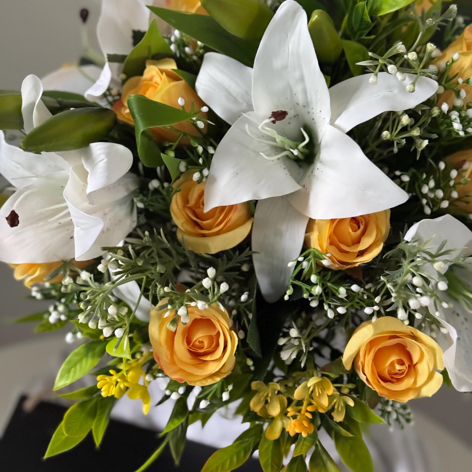 Artificial wedding bridal bouquet with white lilys, yellow rosebuds and foliage