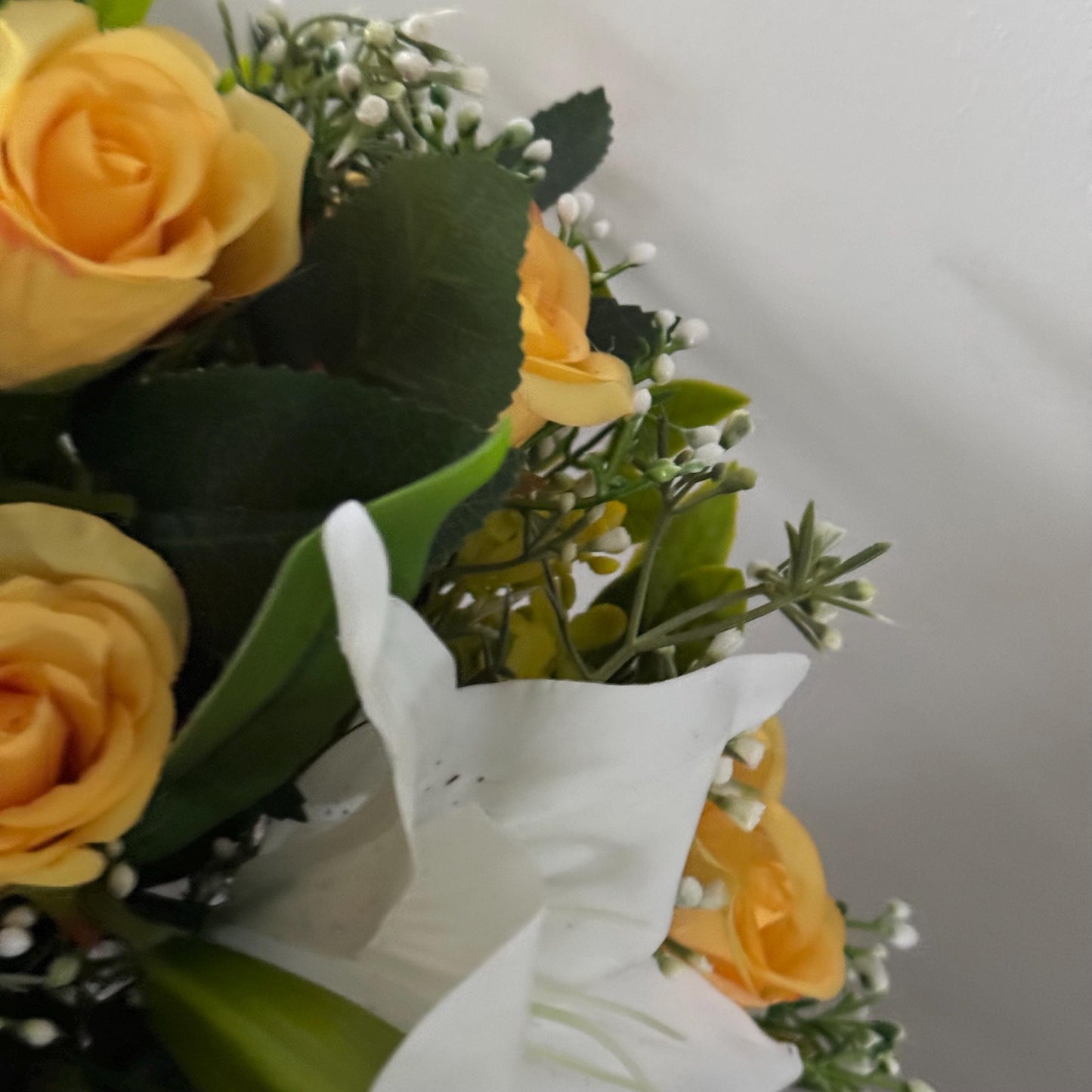 Artificial wedding bridal bouquet with white lilys, yellow rosebuds and foliage