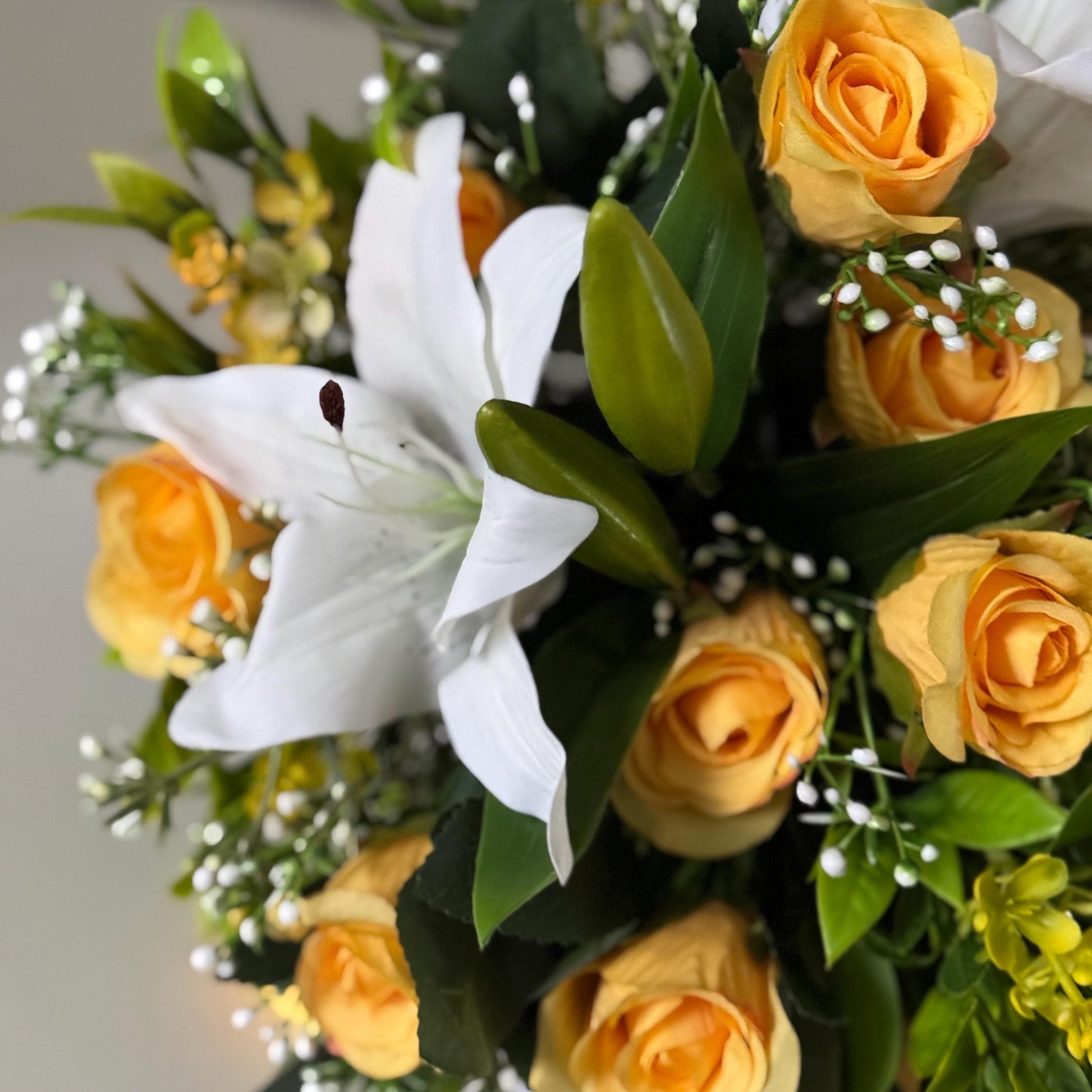 Artificial wedding bridal bouquet with white lilys, yellow rosebuds and foliage