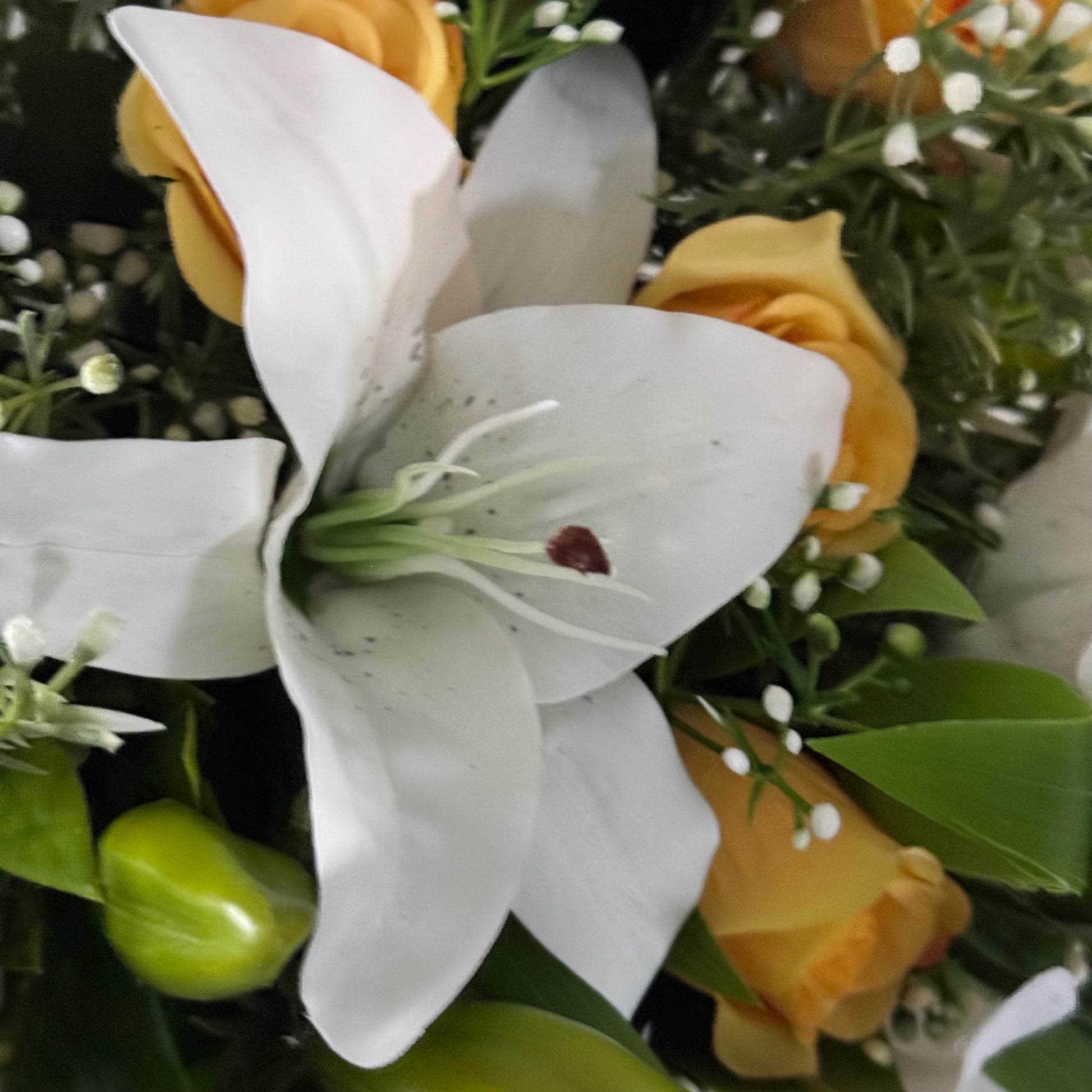 Artificial wedding bridal bouquet with white lilys, yellow rosebuds and foliage