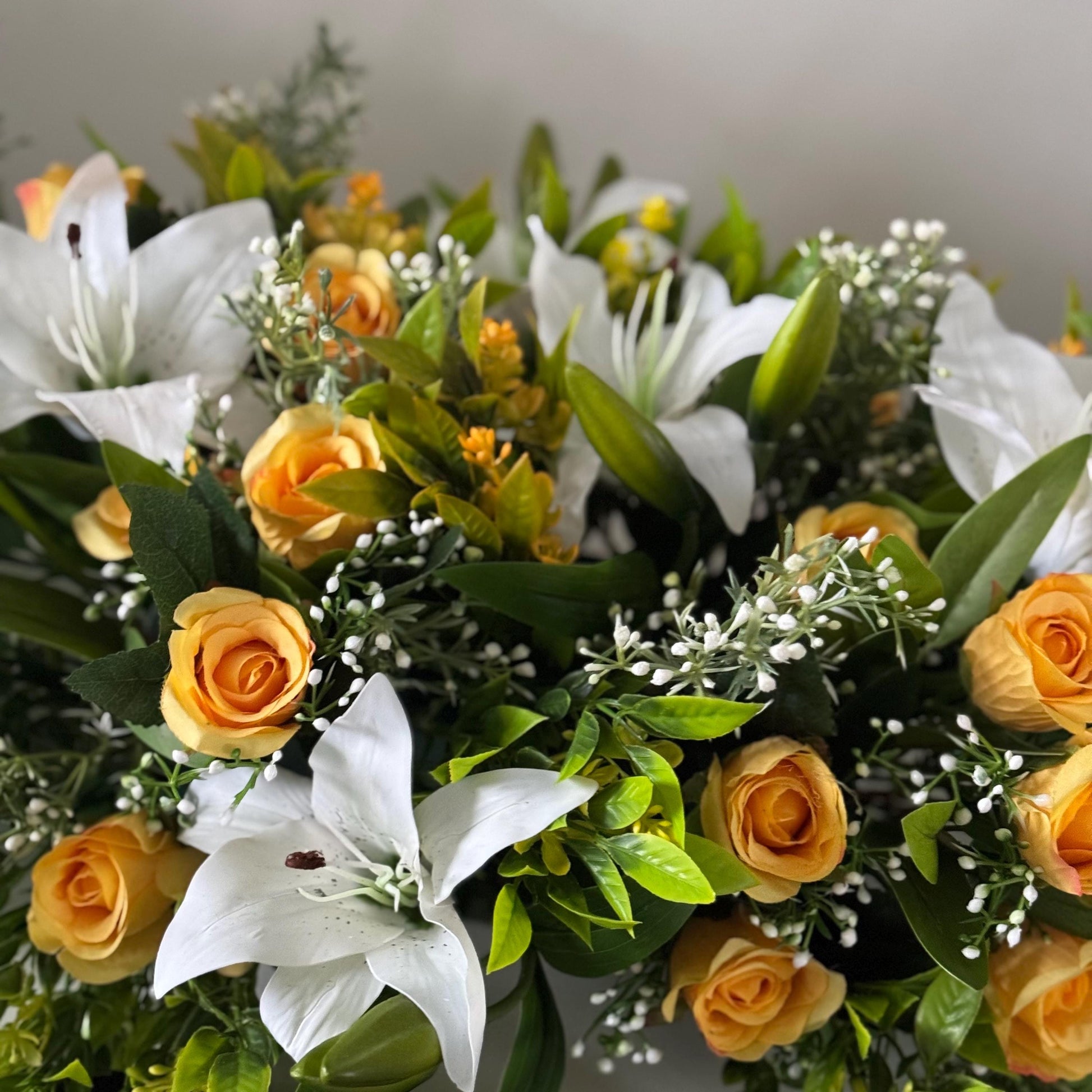 Artificial wedding table centre piece, with white Lilys, yellow rosebuds and foliage. Ideal for spring/summer weddings