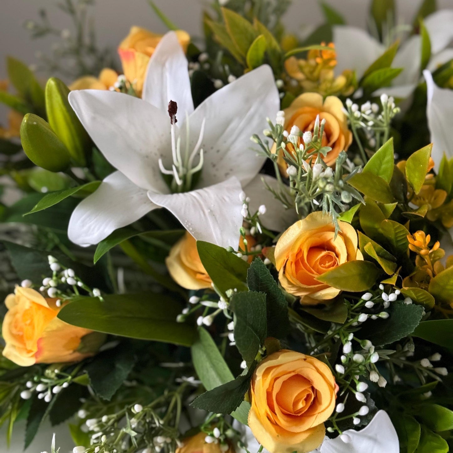 Artificial wedding table centre piece, with white Lilys, yellow rosebuds and foliage. Ideal for spring/summer weddings