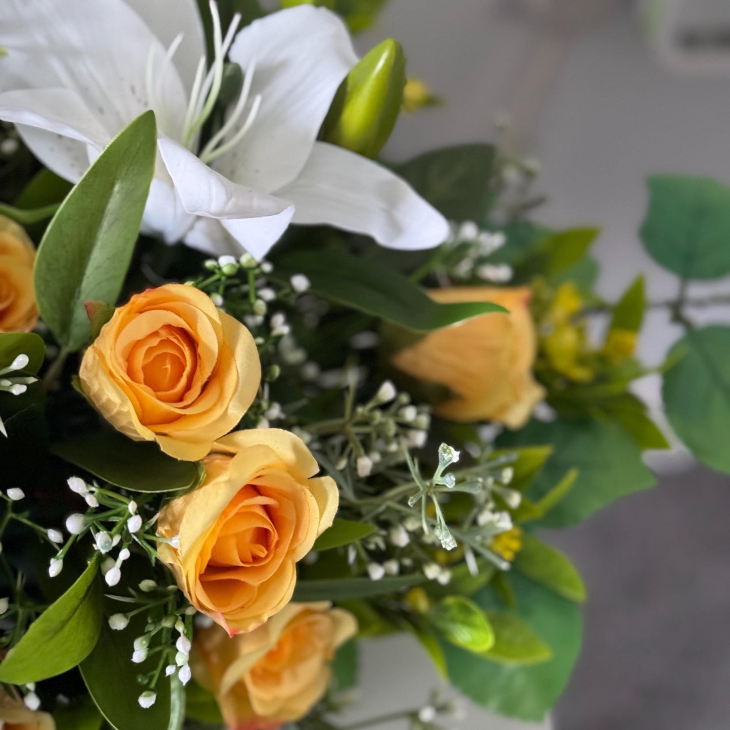 Artificial wedding table centre piece, with white Lilys, yellow rosebuds and foliage. Ideal for spring/summer weddings