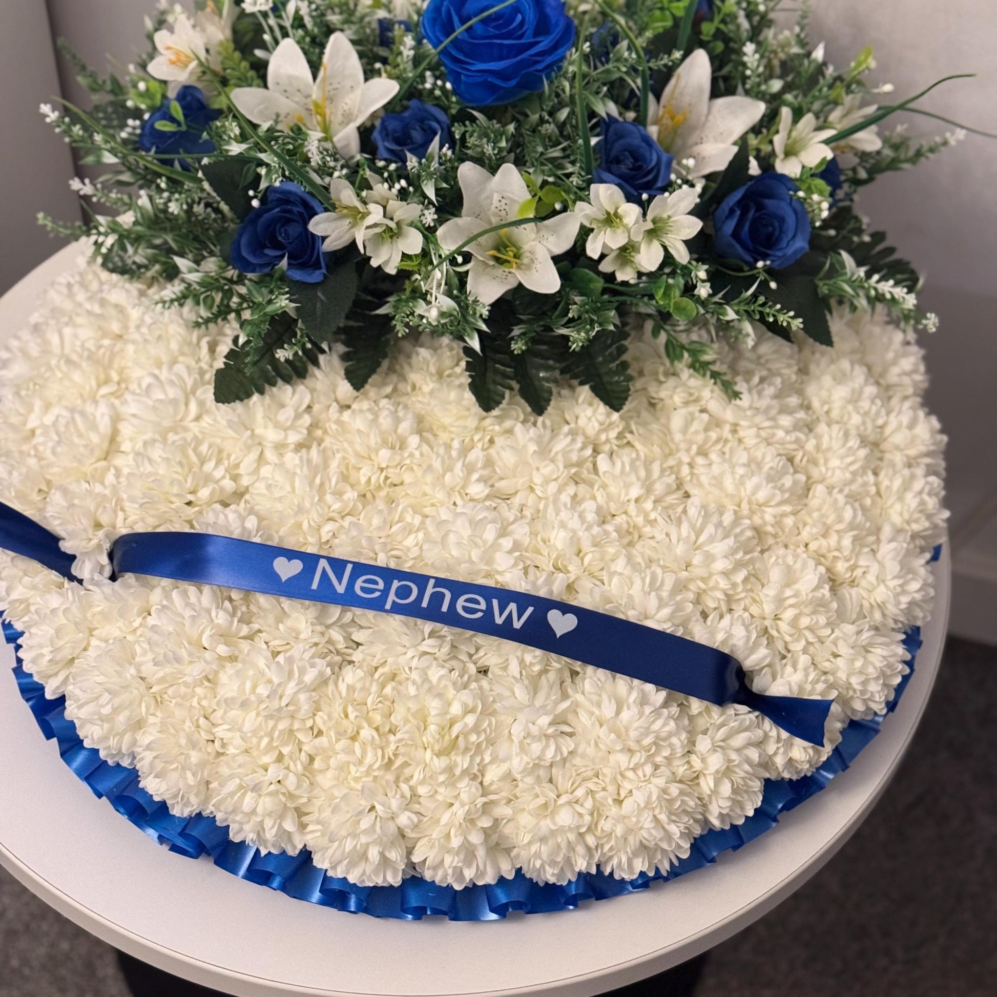 Posey 18 “ Shaped Silk Artificial Funeral Flowers Wreath/Memorial/Grave Tributes with blue roses, white lily’s and green foliage